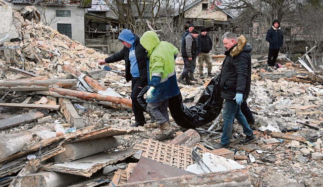 Víctimas. Brigadistas, apoyados por voluntarios, en penosa tarea en el sur de Ucrania. Foto: AFP