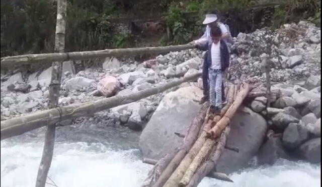 Niños cruzan puente de palos para llegar a sus escuelas. Foto: Captura de pantalla Alba López