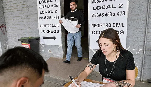 Preparan. Trabajadores del Servel (Servicio Electoral de Chile) ayudan a montar las mesas en los colegios electorales. Foto: AFP