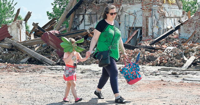 Refugiados. Una niña con su mamá abandonan una ciudad destruida por los bombardeos. Foto: AFP