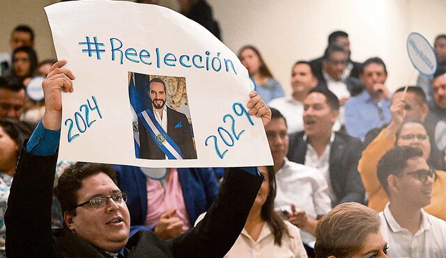 Cruzada reeleccionista. Un congresista oficialista levanta un cartel pro reelección del presidente Nayib Bukele. Foto: AFP