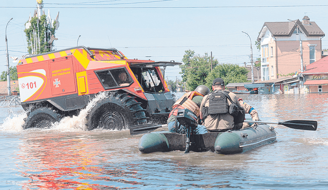 Un camión anfibio y un bote salvavidas ucraniano buscan sobrevivientes entre las calles inundadas. Foto: AFP
