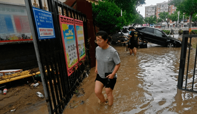 Franjas de los suburbios de la metrópolis china siguen gravemente afectadas por las lluvias, algunas de las más intensas de la ciudad en años. Foto: AFP - Video: Reportera He Beibei de CGTN