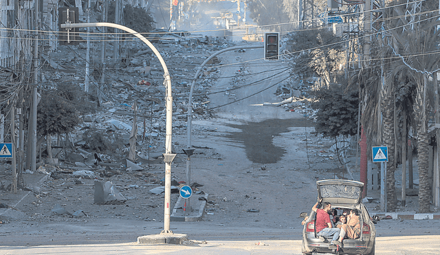 Escombros. Una familia huye entre los restos de su barrio bombardeado desde hace un mes en la Franja de Gaza. Foto: difusión