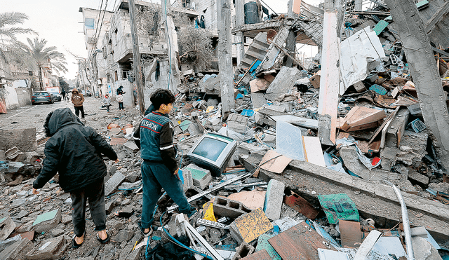 Destrucción. Cientos de niños palestinos intentan salvar algunas pertenencias en medio de la ocupación israelí en Gaza. Foto: AFP