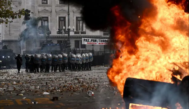 Los manifestantes han sido reprimidos con bombas lacrimógenas debido a la quema de vehículos en los exteriores del senado argentino. Foto. AFP