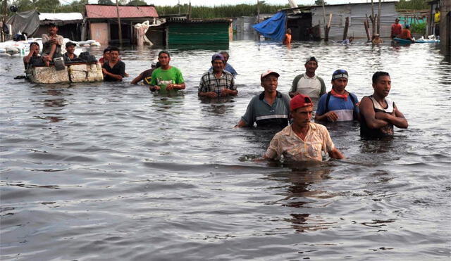 Pobladores obligados a caminar sobre las aguas. Foto: Andina