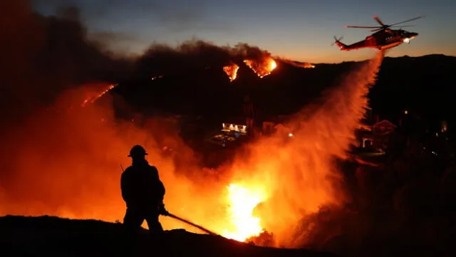 Bomberos y autoridades en helicópteros trabajan de manera conjunta para calmar el fuego. en San Diego.Foto: CDN