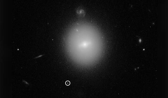 El agujero negro se indica en el círculo blanco, en las afueras de una galaxia. Crédito: NASA.