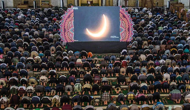 Cientos de fieles musulmanes rezan ante la imagen del eclipse anular solar. Foto: AFP.