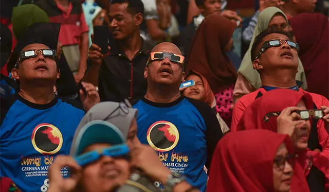 Las personas usaron lentes protectores para ver el fenómenos astronómico. Foto: AFP.