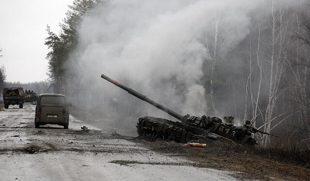 El humo se eleva desde un tanque ruso destruido por las fuerzas ucranianas al costado de una carretera en la región de Lugansk el 26 de febrero de 2022. Foto: AFP
