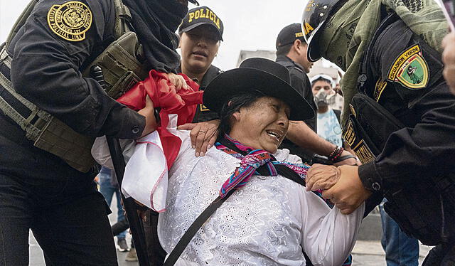 Detención. Sin motivo, cinco efectivos policiales la detuvieron y arrebataron la bandera. Foto: Luis Javier Maguiña/La República   