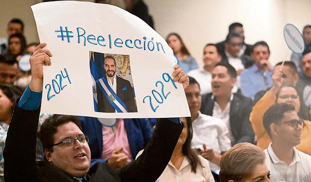 Cruzada reeleccionista. Un congresista oficialista levanta un cartel pro reelección del presidente Nayib Bukele. Foto: AFP   