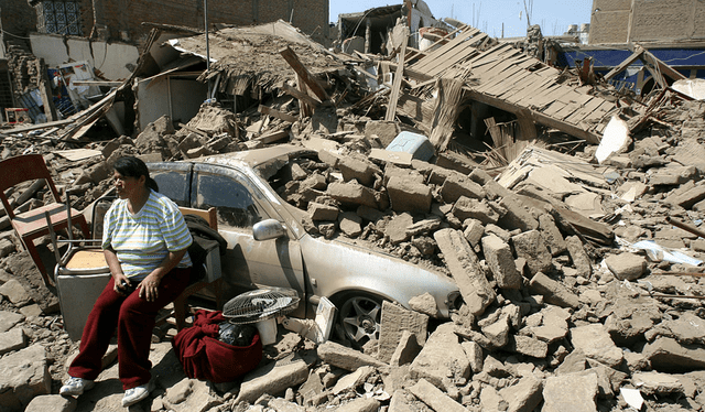  Una mujer sentada en la fachada de su casa derrumbada durante el terremoto de Pisco de 2007. Foto: AFP    