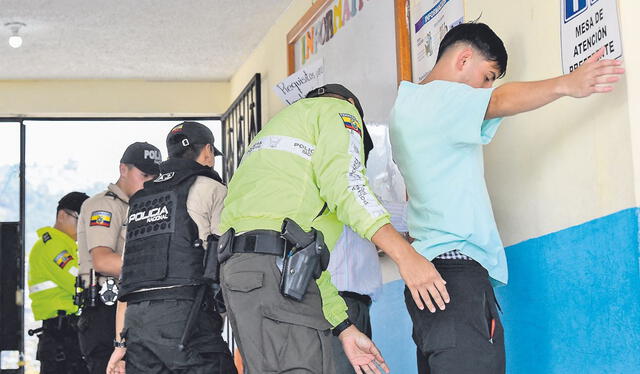 Seguridad. Agentes de policía registran a los votantes en un colegio electoral en Quito. Foto: AFP.   