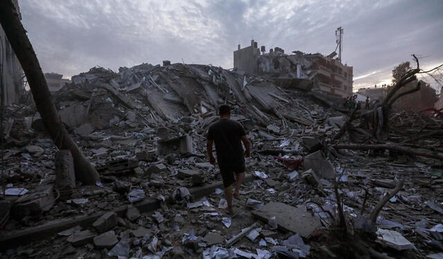 Palestinos inspeccionan los alrededores destruidos de la Torre Palestina después de que aviones de combate israelíes la atacaran en la ciudad de Gaza. Foto: EFE   