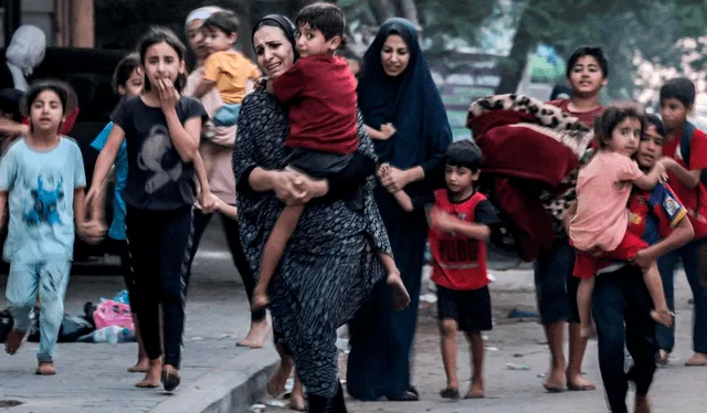  Mujeres y niños huyen por una calle de Gaza tras advertencias de Israel. Foto: Mohammed Abed/AFP   