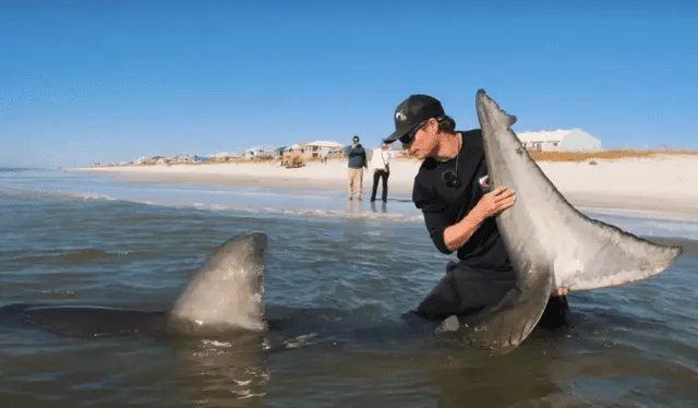 Blaine Kenny con el tiburón blanco que cazó durante su travesía en Navarrete Beach. Foto: Coastal worldwide&nbsp;/YouTube    