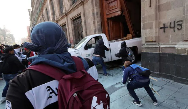 Frases como "Faltan 43" o "Solo queremos un diálogo" fueron las que los manifestantes dejaron en Palacio Nacional. Foto: AFP   