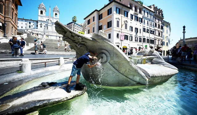 Un niño se refresca en la fuente de la Barcaccia, cerca de la Plaza de España, durante una ola de calor en Roma. Foto: AFP   