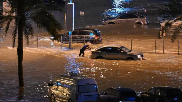 Ciudadano empuja su carro atrapado en medio de las inundaciones que afectan a Dubái debido a las lluvias. Foto: Khaleej Times   