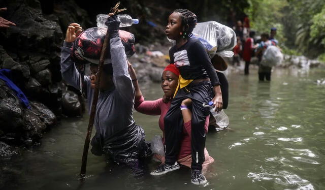 Migrantes haitianos vadean el agua mientras cruzan la región del Darién de Colombia a Panamá. Foto: Associated Press Iván Valencia   