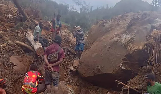Residentes ayudando a desenterrar en zona afectada por avalancha. Foto: AFP   