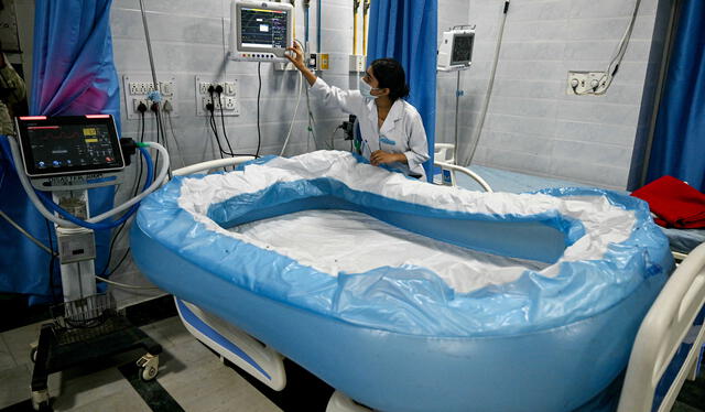 Un miembro del personal médico prepara una cama de hielo inflada en la sala de insolación del hospital Ram Manohar Lohia de Nueva Delhi. Foto: AFP   