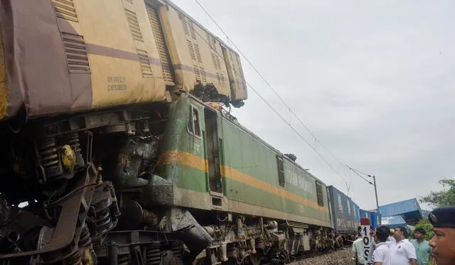 Varias personas se reúnen cerca del lugar de la colisión entre un tren de pasajeros y otro de mercancías en Nirmaljote. Foto: AFP   