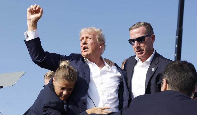 Donald Trump levanta el puño derecha hacia los asistentes mientras sangra por el oído derecho. Fuente: AFP   