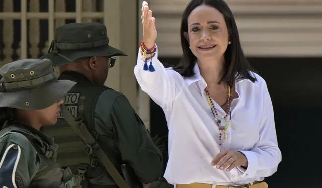  Machado buscó el saludo de cada uno de los miembros militares que custodiaban el local de votación. Foto: AFP   