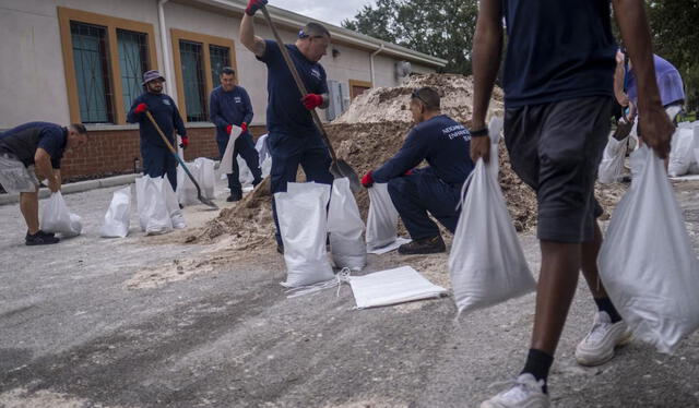 Ciudadanos trasladan sacos de arena a sus casas. Foto: ABC   