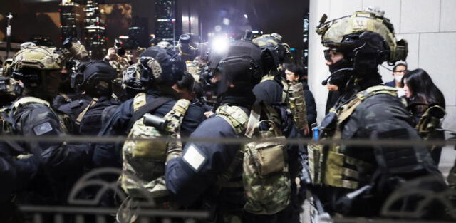  Luego de la instauración de la ley marcial, las fuerzas militares se alistan para ingresar al salón principal de la Asamblea Nacional. Foto: EFE   