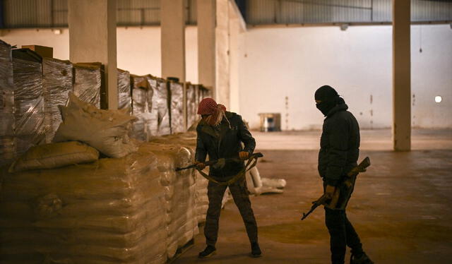  Combatientes rebeldes sirios inspeccionan sacos marcados como "hecho en Arabia Saudita" que contienen hojuelas de soda cáustica. Foto: AFP   