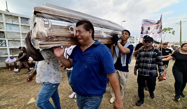  Familiares y amigos de las víctimas cargan uno de los ataúdes. Foto: AFP   