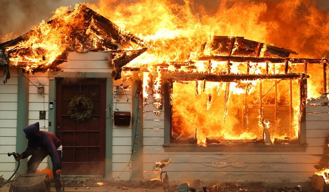  Un residente utiliza una manguera para intentar apagar el incendio de una vivienda en Altadena, California, el pasado 8 de enero.Foto: El País    