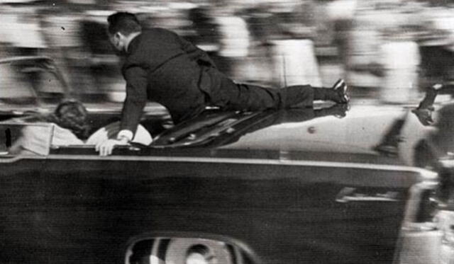  El agente del Servicio Secreto, Clint Hill, empujó a la primera dama, Jacqueline Kennedy, de regreso a su asiento tras el impacto de bala que recibió el presidente John F. Kennedy en la limusina presidencial. Foto: difusión.   
