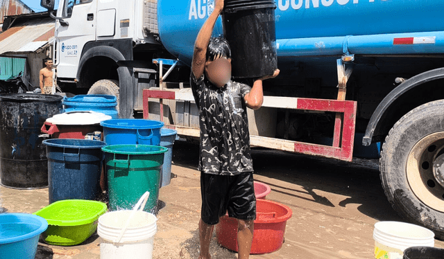  Niños recolectan agua en baldes. Algunos faltan al colegio por esperar que llegue la cisterna. Foto: Yazmín Araujo.   