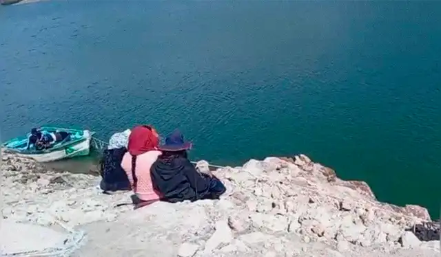  Familiares de Félix permanecen durante varias horas a orillas de la laguna esperando alguna señal. Foto: cortesía.<br><br>    