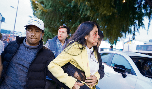  Herida en el rostro. Una integrante del equipo de campaña huye del lugar del atentado. Foto: EFE   