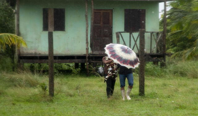 Una pareja camina con un paraguas debido a las fuertes lluvias por la proximidad del huracán Eta en Bilwi, costa norte de Nicaragua. Foto: EFE