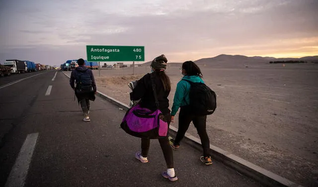 Reinaldo (i), Anyier (c) y su hija Danyierly tras cruzar Bolivia y llegar a Colchane, Chile. Foto: AFP