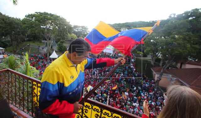 Nicolás Maduro ondea una bandera de su país frente a simpatizantes durante un acto de gobierno en Caracas. Foto: EFE