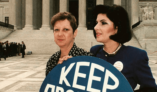 Jane Roe en el histórico fallo Roe vs. Wade de 1973, sosteniendo un cartel a favor del aborto con la abogada Gloria Allred (derecha).