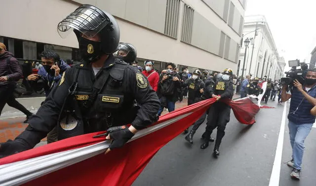 Policía intentó quitar una bandera peruana a los manifestantes.