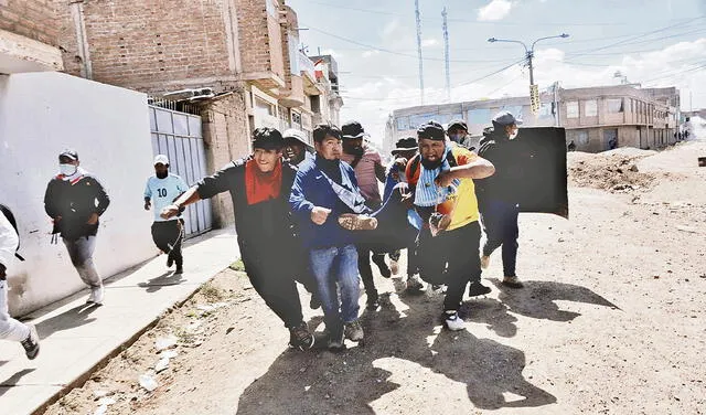 Un grupo de desesperados manifestantes llevan a un herido en busca de atención. Juliaca fue ayer un polvorín. La mayoría de los heridos recibieron impactos de balas y perdigones. Foto: Foto: Liubomir Fernández/ URPI - LR