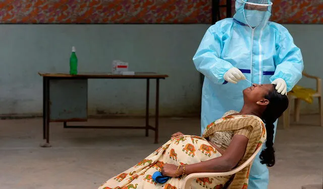 Una embarazada mientras le hacen una prueba de COVID-19 en India. Foto: AFP