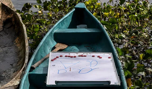 La profesora Graciela lleva sus implementos en canoa. Foto: AFP