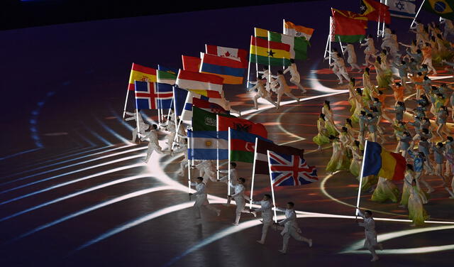 Artistas ondean banderas nacionales durante la ceremonia de clausura de los Juegos Olímpicos de Invierno de Beijing 2022. Foto. AFP